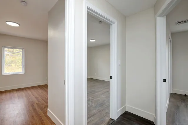 a view of a hallway with wooden floor