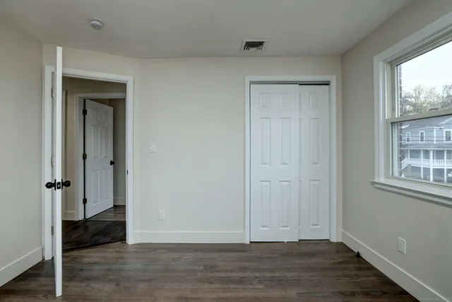 an empty room with wooden floor and a window