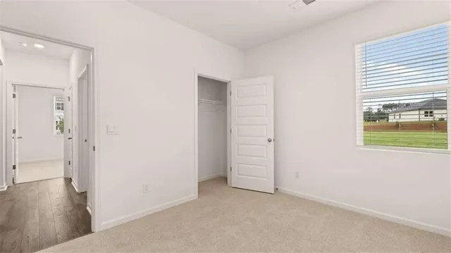an empty room with windows and closet