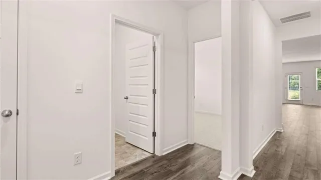 a view of a hallway with wooden floor