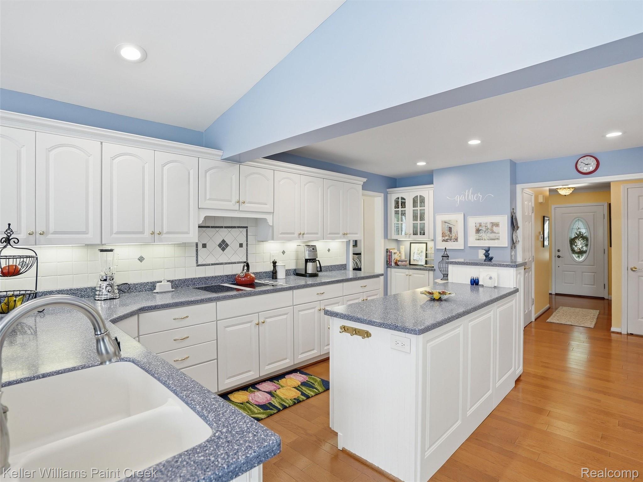 1351 West Fairview Lane Rochester, MI 48306 - Photo 22 of 65 Kitchen with white cabinetry, vaulted ceiling, recessed lighting, glass insert cabinets, and light wood-style floors