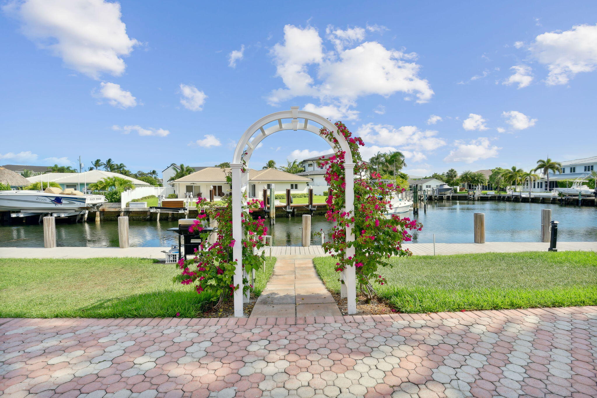 698 Northeast Spanish River Boulevard, Unit 24 Boca Raton, FL 33431 - Photo 21 of 25 a front view of a house with a yard and potted plants