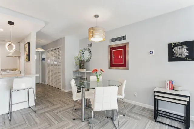 a dining room with wooden floor a chandelier a wooden table and chairs