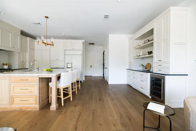 a kitchen with a table chairs refrigerator and cabinets