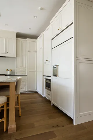 a kitchen with granite countertop white cabinets and stainless steel appliances