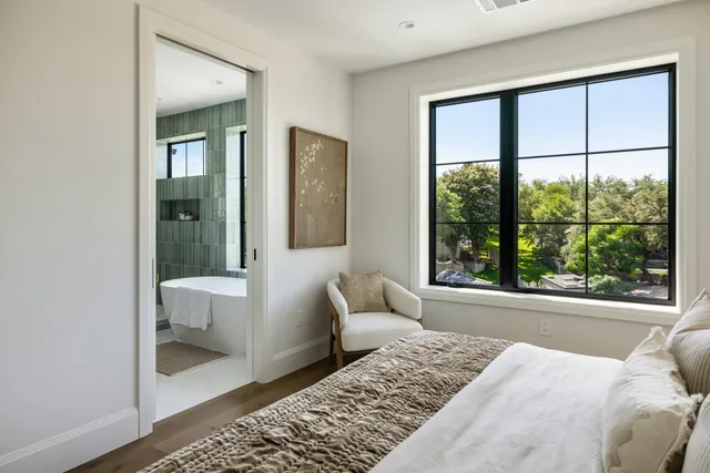 a bedroom with a bed and a large window