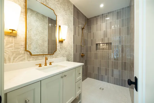 a bathroom with a shower sink vanity and mirror