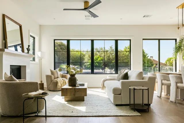 a living room with fireplace furniture and a floor to ceiling window