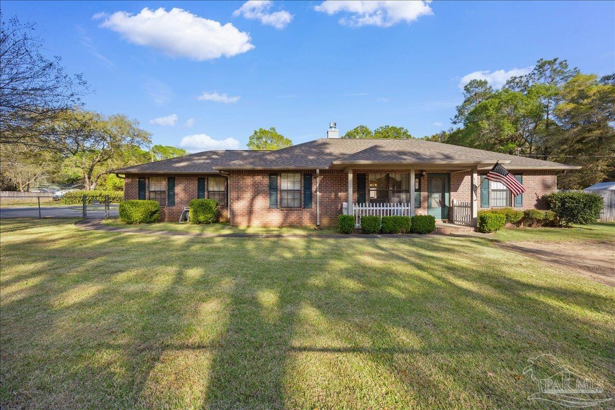 6892 Yucatan Street Milton, FL 32570 - Photo 1 of 41 a front view of a house with a garden