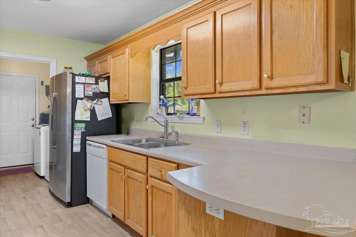 6892 Yucatan Street Milton, FL 32570 - Photo 12 of 41 a kitchen with stainless steel appliances granite countertop a sink a refrigerator and a cabinets