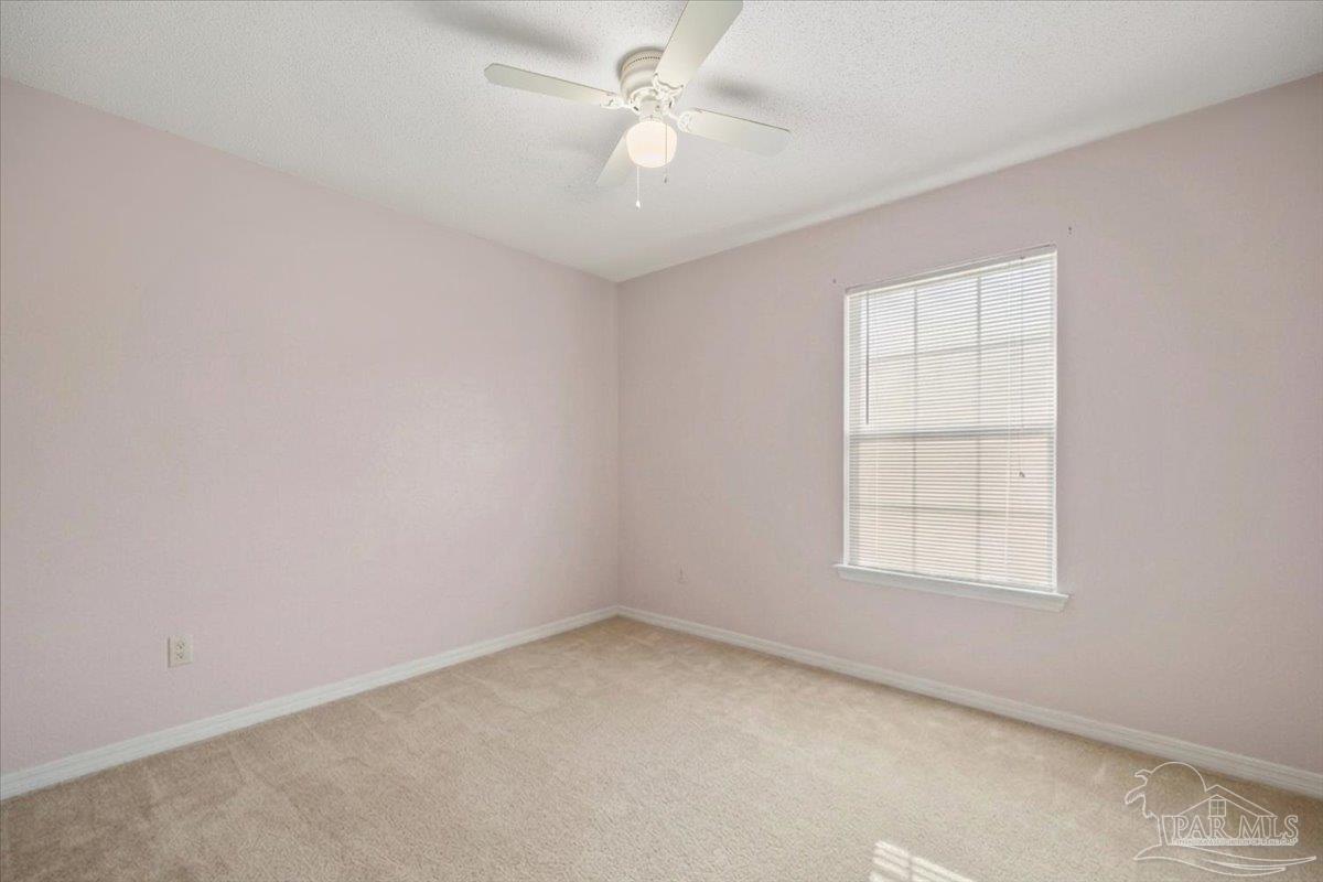 6892 Yucatan Street Milton, FL 32570 - Photo 13 of 41 an empty room with a window and a fan