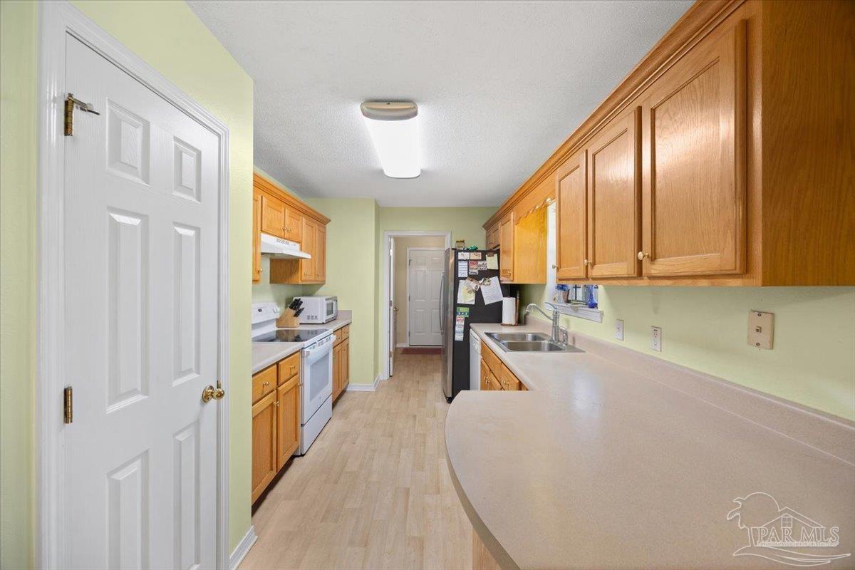 6892 Yucatan Street Milton, FL 32570 - Photo 15 of 41 a view of a kitchen with kitchen island granite countertop lots of counter top space and stainless steel appliances