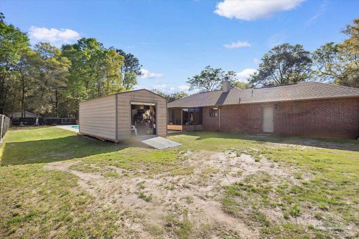 6892 Yucatan Street Milton, FL 32570 - Photo 26 of 41 a front view of a house with a garden and yard