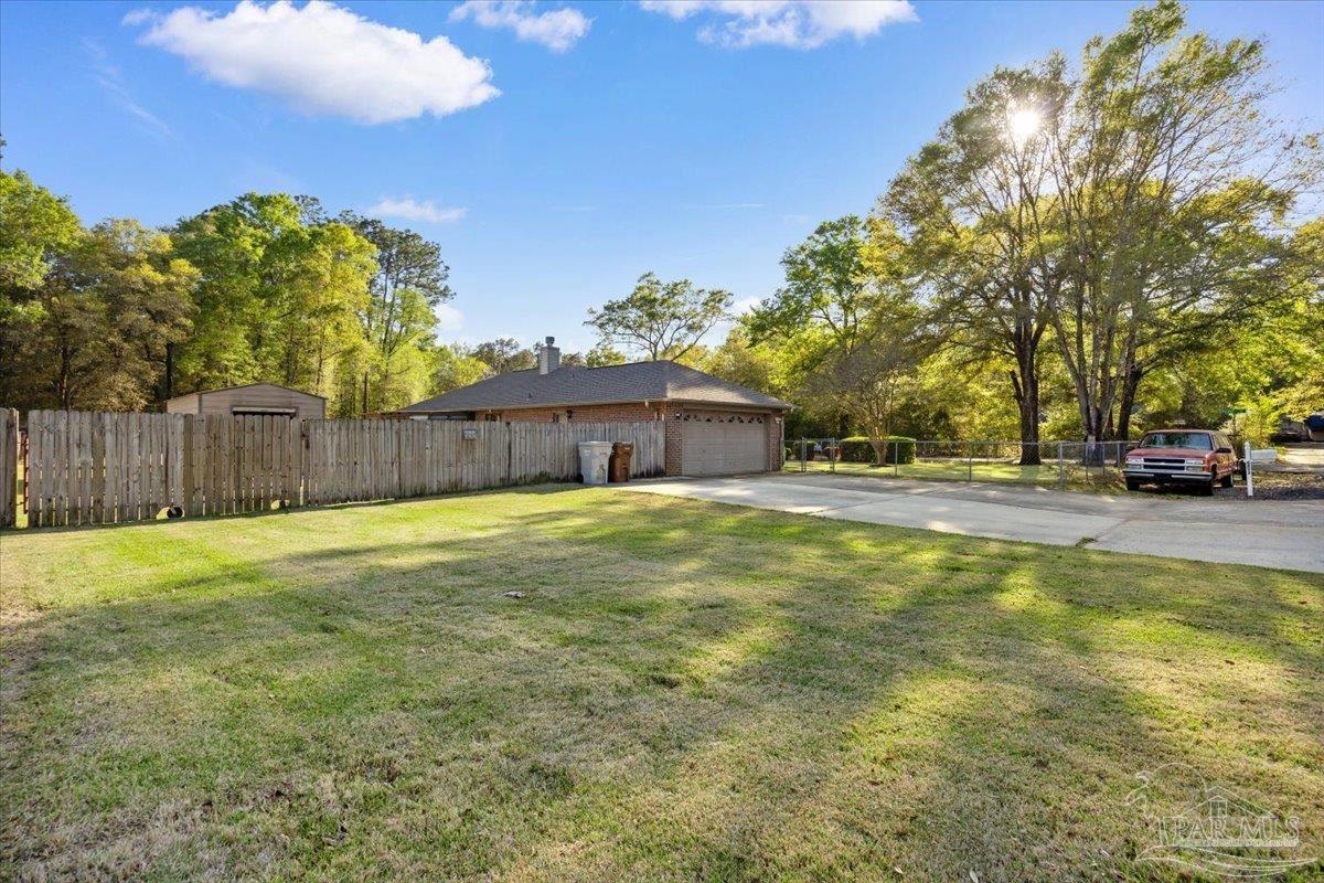 6892 Yucatan Street Milton, FL 32570 - Photo 27 of 41 a swimming pool with outdoor seating and yard