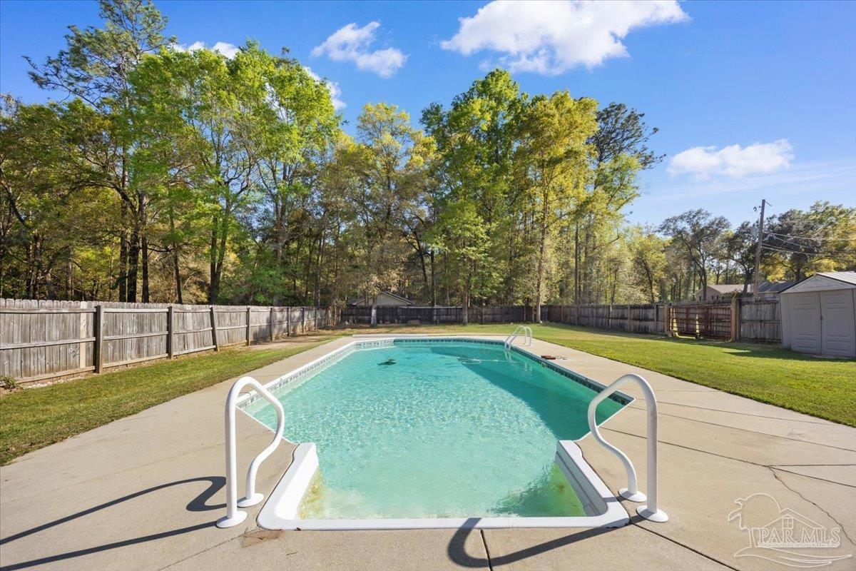 6892 Yucatan Street Milton, FL 32570 - Photo 29 of 41 a view of a swimming pool with a yard