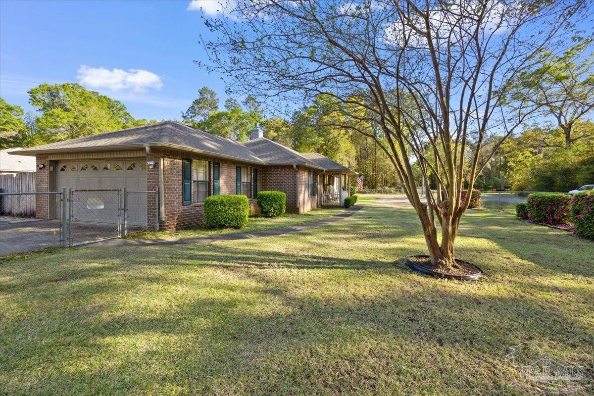 6892 Yucatan Street Milton, FL 32570 - Photo 30 of 41 a view of a house with a yard