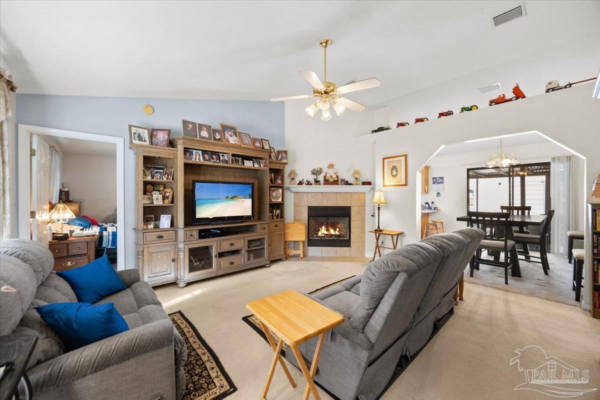 6892 Yucatan Street Milton, FL 32570 - Photo 3 of 41 a living room with furniture a flat screen tv and a fireplace