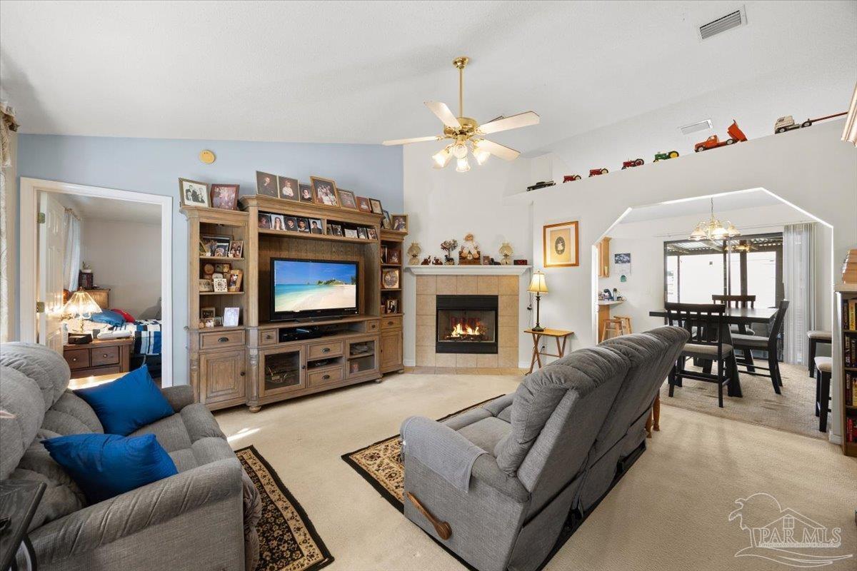6892 Yucatan Street Milton, FL 32570 - Photo 5 of 41 a living room with furniture a flat screen tv and a fireplace