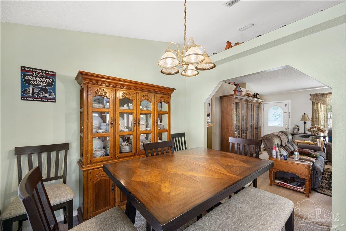 6892 Yucatan Street Milton, FL 32570 - Photo 8 of 41 a room with chandelier furniture and wooden floor