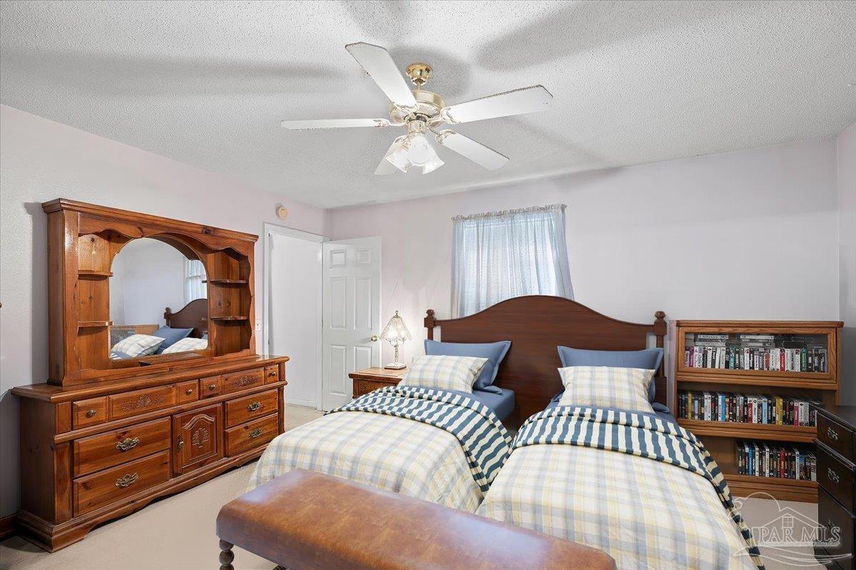 6892 Yucatan Street Milton, FL 32570 - Photo 9 of 41 a bedroom with a bed and a dresser in it