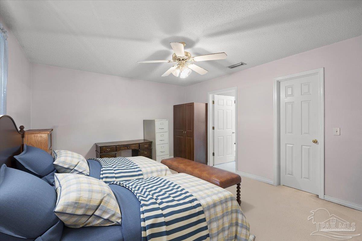 6892 Yucatan Street Milton, FL 32570 - Photo 10 of 41 a bedroom with bed and a chandelier