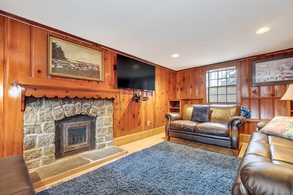 87 Payson Road Brookline, MA 02467 - Photo 32 of 41 a living room with furniture a flat screen tv and a fireplace