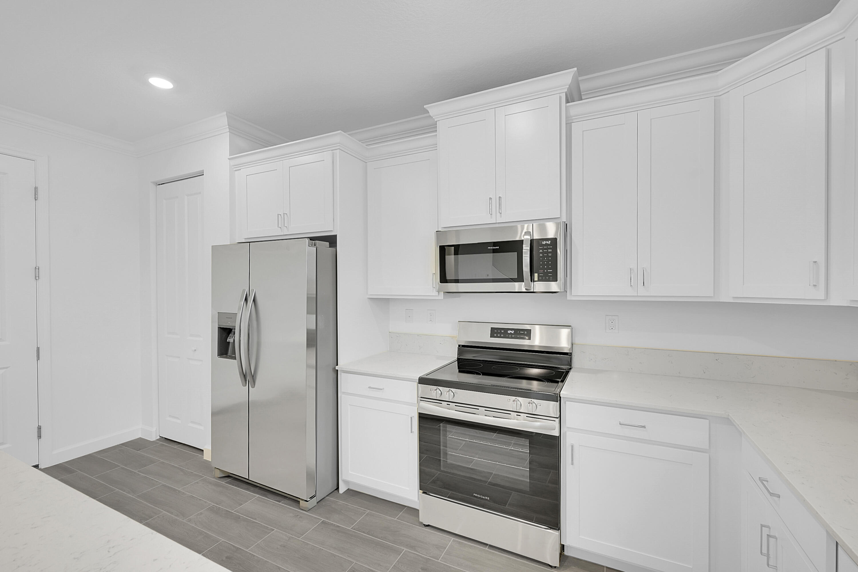 3514 Angler Drive Fort Pierce, FL 34946 - Photo 12 of 32 a kitchen with white cabinets and stainless steel appliances