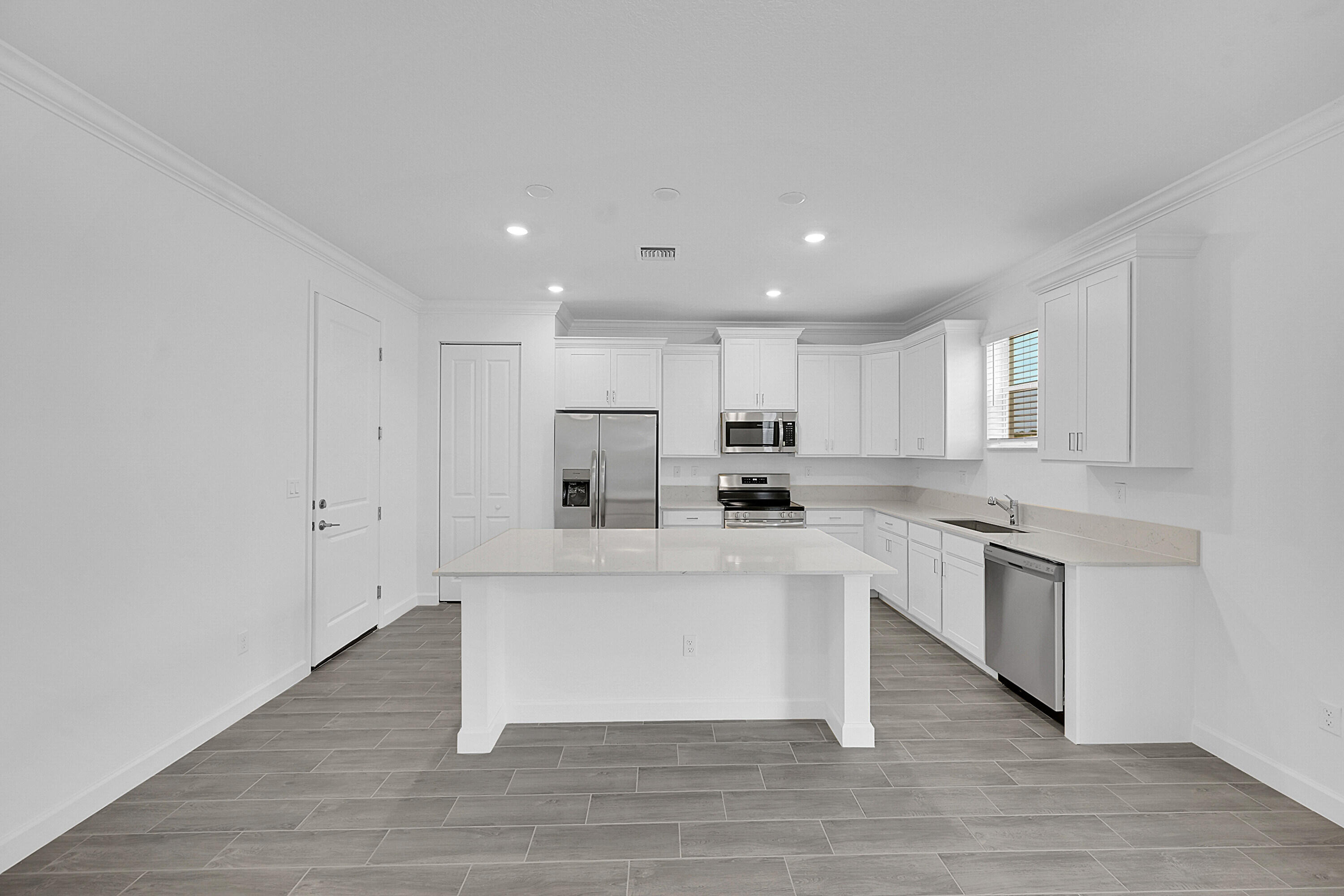 3514 Angler Drive Fort Pierce, FL 34946 - Photo 13 of 32 a large white kitchen with stainless steel appliances granite countertop a stove a sink dishwasher and a refrigerator with wooden floor