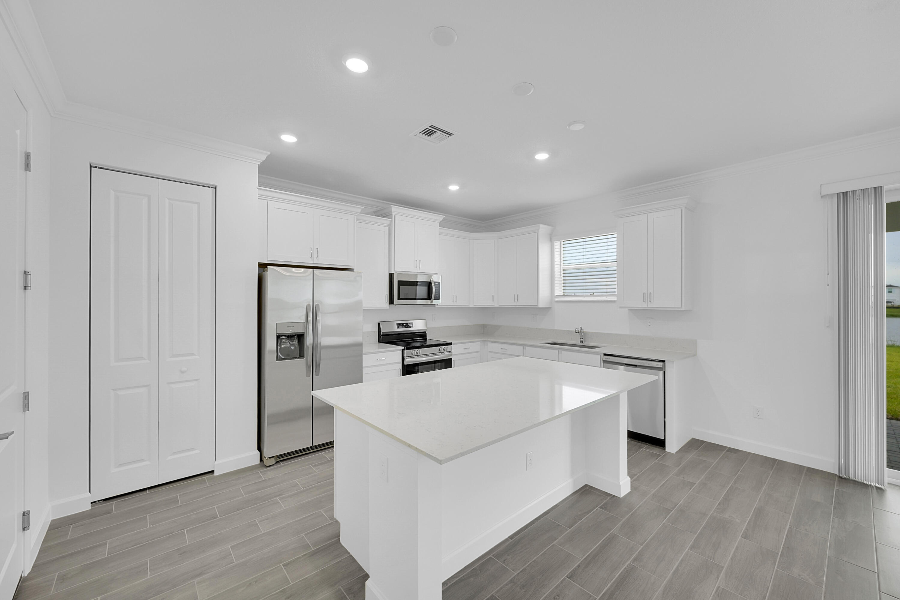 3514 Angler Drive Fort Pierce, FL 34946 - Photo 10 of 32 a kitchen with a sink a stove a refrigerator and white cabinets