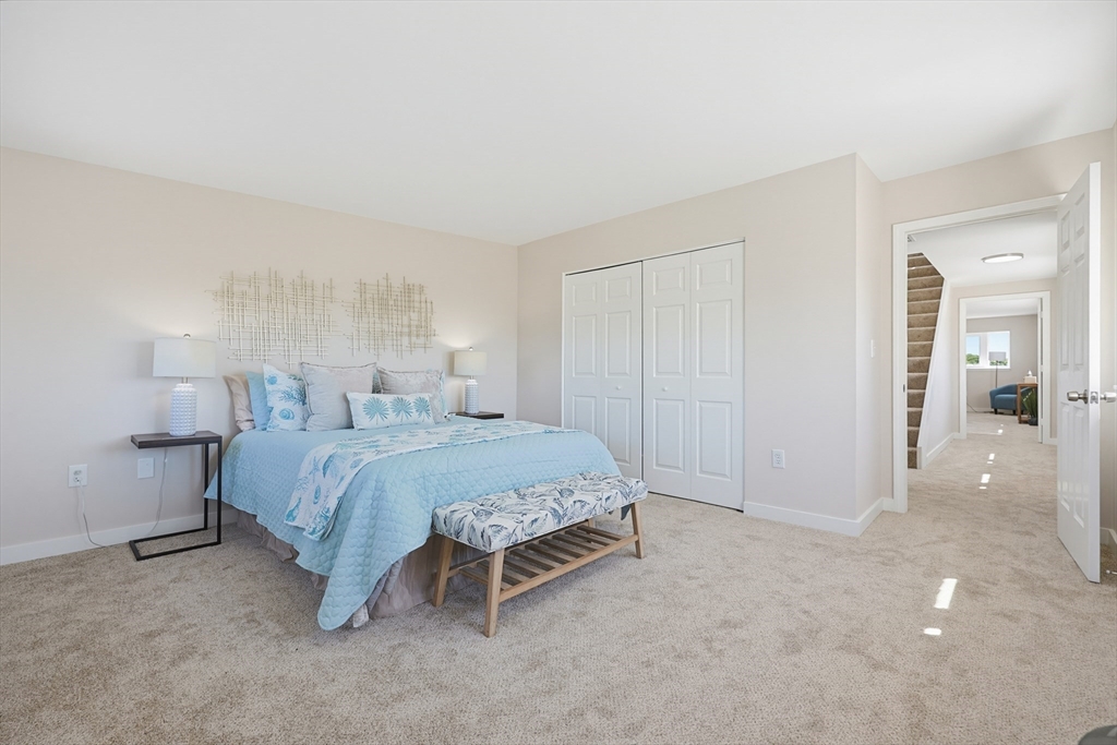 45 Main Street, Unit 35 Wareham, MA 02571 - Photo 14 of 34 a spacious bedroom with a bed and a lamp