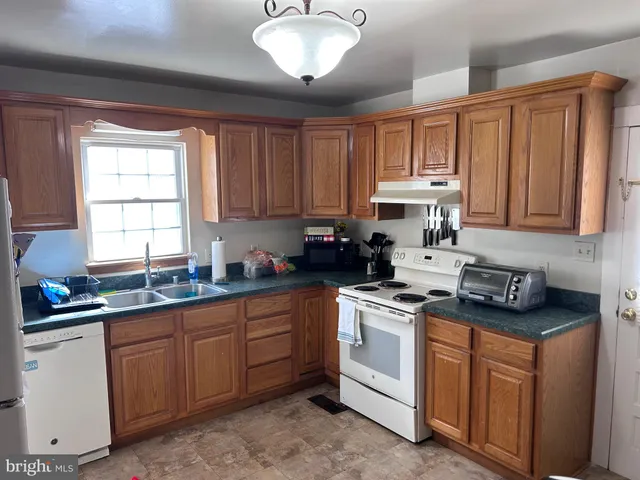 a kitchen with stainless steel appliances granite countertop a sink stove and cabinets