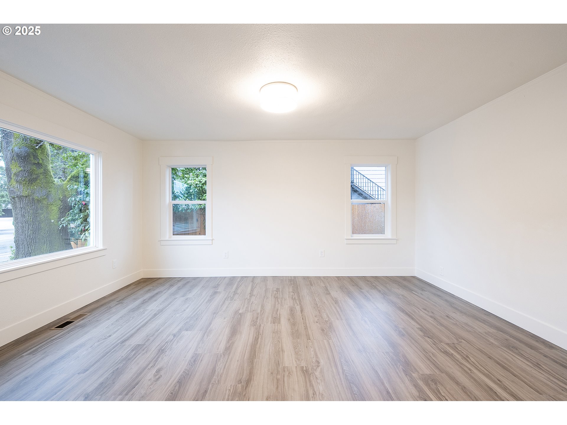 11129 Southeast Stark Street Portland, OR 97216 - Photo 3 of 20 wooden floor in an empty room with a window