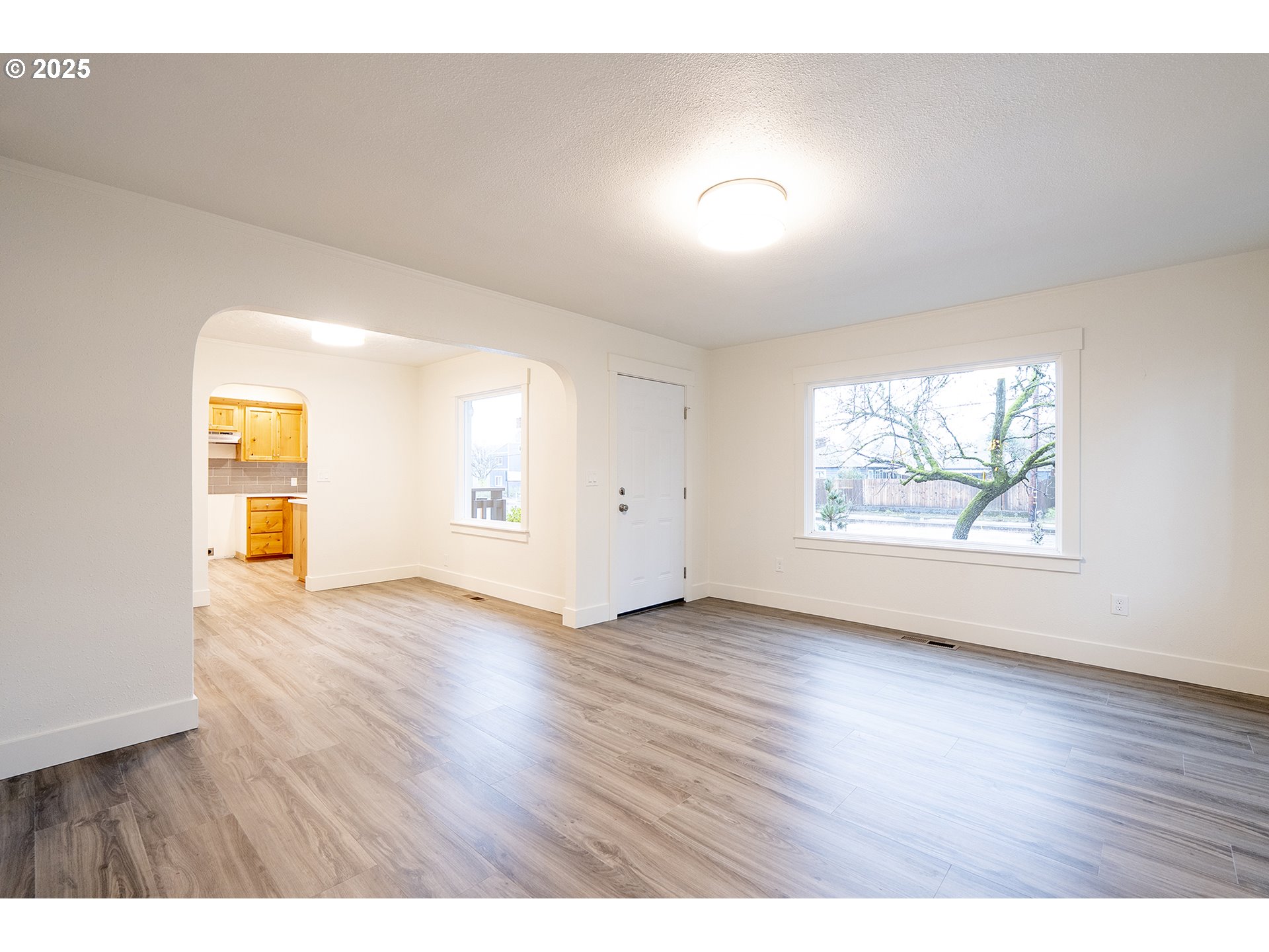 11129 Southeast Stark Street Portland, OR 97216 - Photo 5 of 20 an empty room with wooden floor and window