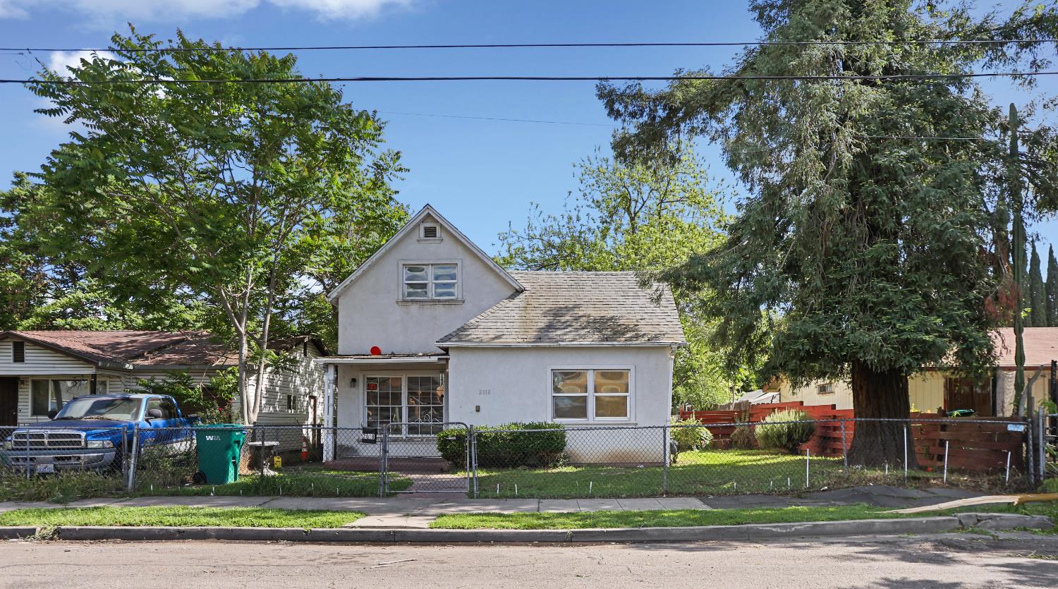 a front view of a house with a yard and potted plants