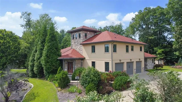 a front view of a house with yard and green space