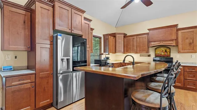 a kitchen with stainless steel appliances granite countertop a sink refrigerator and cabinets