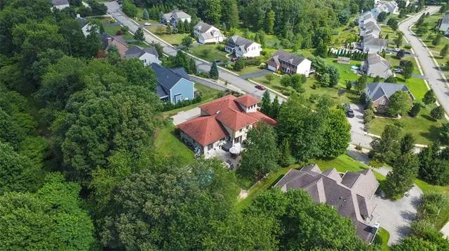 an aerial view of residential house with outdoor space and trees all around