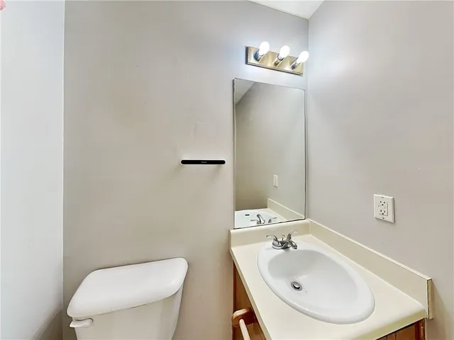 a bathroom with a toilet sink and mirror
