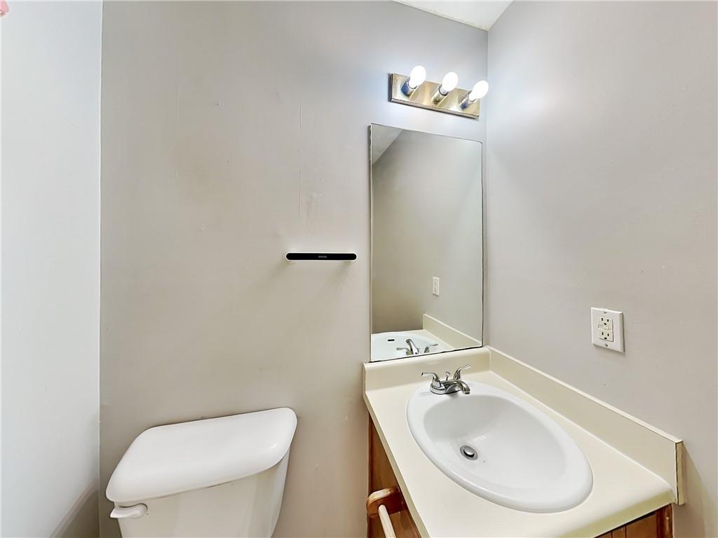 2140 Kings Gate Circle Southwest, Unit B Snellville, GA 30078 - Photo 12 of 18 a bathroom with a toilet sink and mirror
