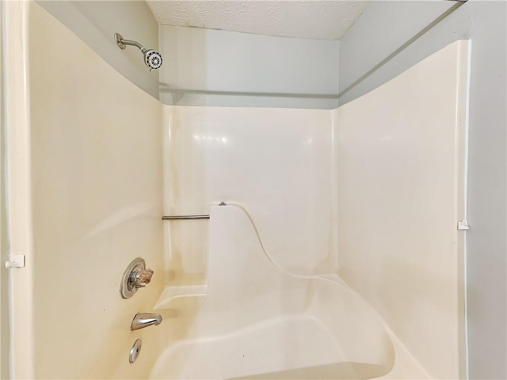 2140 Kings Gate Circle Southwest, Unit B Snellville, GA 30078 - Photo 15 of 18 a bathroom with a bathtub and shower