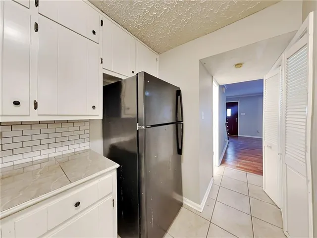 a kitchen with a refrigerator and a stove top oven
