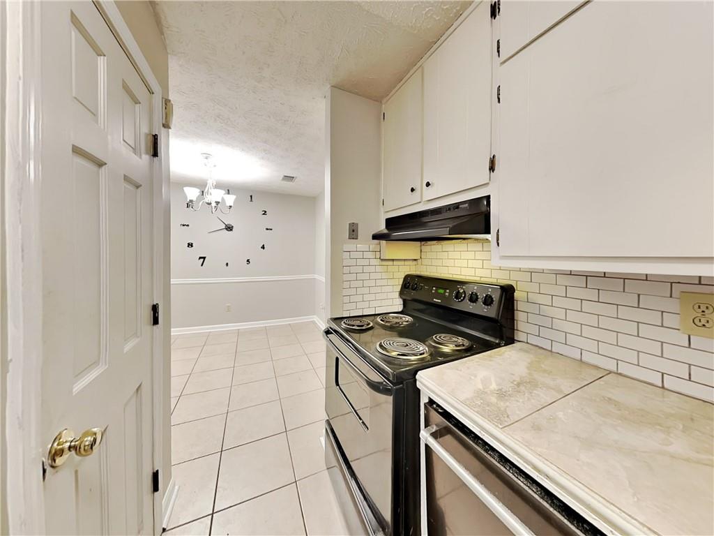 2140 Kings Gate Circle Southwest, Unit B Snellville, GA 30078 - Photo 7 of 18 a kitchen with granite countertop a stove a sink and a refrigerator