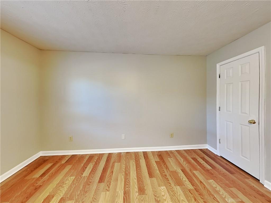 2140 Kings Gate Circle Southwest, Unit B Snellville, GA 30078 - Photo 9 of 18 a view of an empty room and wooden floor