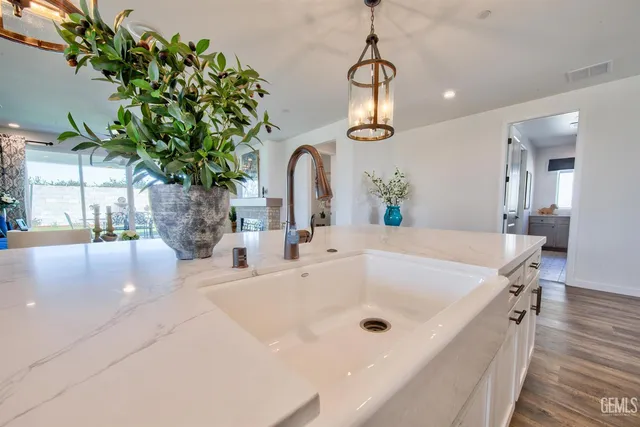 a bathroom with a sink a mirror and a potted plant