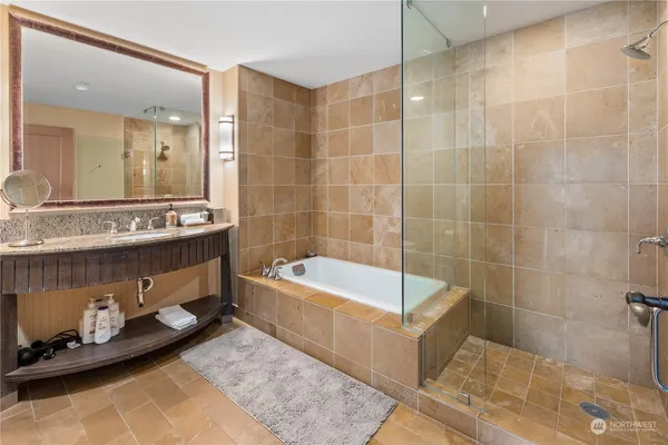 a bathroom with a tub a sink and a shower