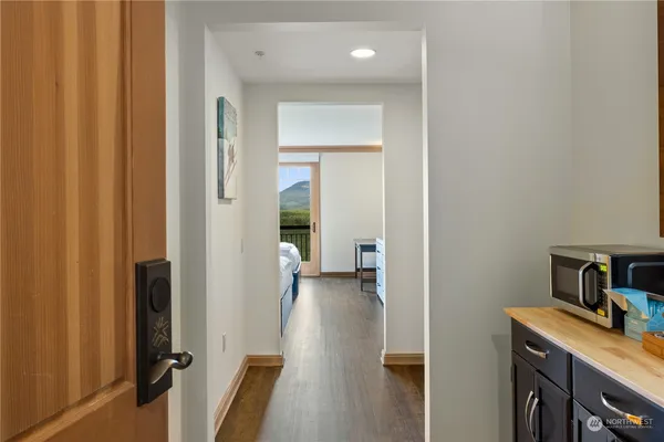 a view of a hallway with wooden floor and closet