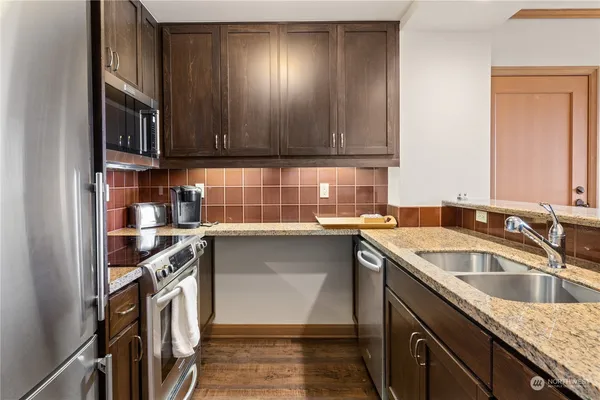 a kitchen with stainless steel appliances granite countertop a sink stove and cabinets