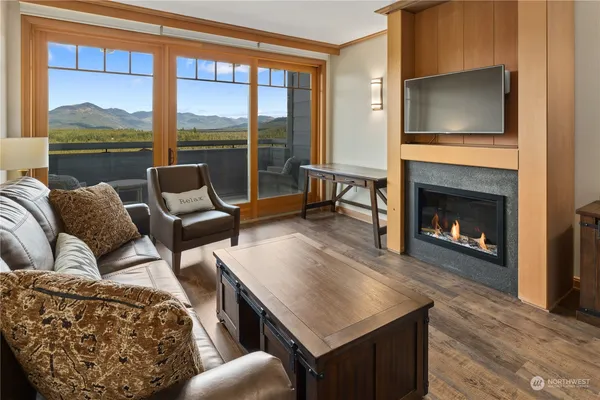 a living room with furniture a fireplace and a floor to ceiling window