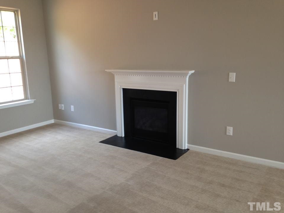 2712 Shepherd Valley Street Raleigh, NC 27610 - Photo 5 of 21 an empty room with windows and fireplace
