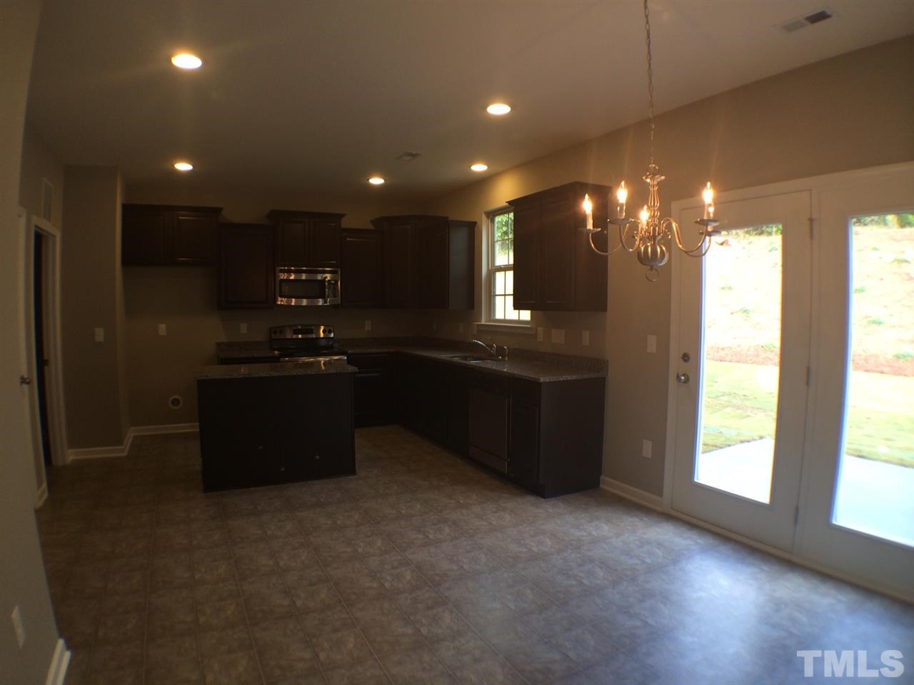 2712 Shepherd Valley Street Raleigh, NC 27610 - Photo 7 of 21 a kitchen with kitchen island granite countertop a sink and a stove top oven